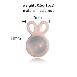 Macro shot of 7x11mm pink ceramic rabbit earring backs showing weight and dimensions