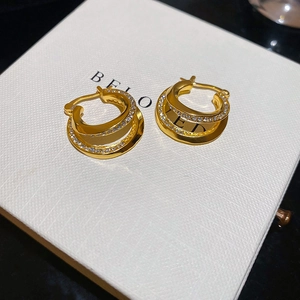 Macro shot of double-layer gold hoop earrings with pavé diamonds and polished finish
