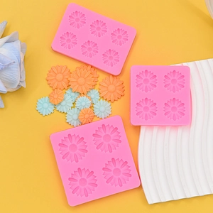 Close-up of pink daisy silicone molds with finished colorful fondant flower decorations