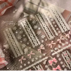 Detail view of 3D embossed nail stickers featuring white cable knit and pink bow designs