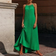 Dettaglio dell'abito lungo a pieghe verde smeraldo con elegante design allacciato al collo