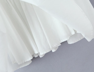Detail of white square neck mini dress showing pleated fabric texture and fine sewing