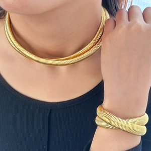 Golden double-layer snake chain necklace and bracelet set shown on female model