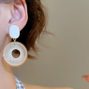 Detail of bohemian dreamcatcher earrings with gold circular frame and white woven mesh