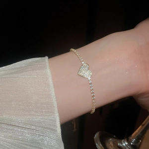 Detailed view of elegant gold heart bracelet with pavé zircons on model's wrist