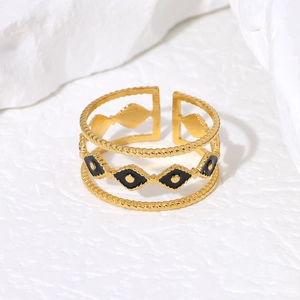 Detailed close-up of golden stainless steel open ring with black evil eye enamel drip design