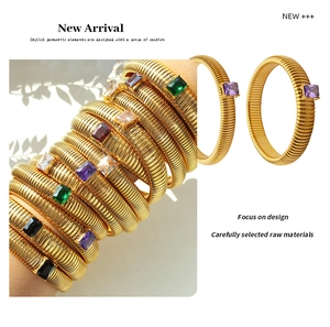 Detailed macro view of gold-plated elastic bracelets with textured wavy bands and square zircons