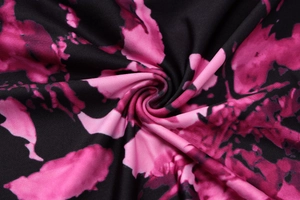 Vista dettagliata del tessuto tie-dye nero e magenta con trama a maglia flessibile