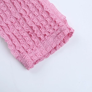 Vue macro détaillée du tissu en dentelle rose avec texture ondulée et motif floral élégant