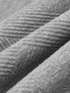 Macro shot of gray heavy-knit fabric texture on vintage quarter-zip sweater