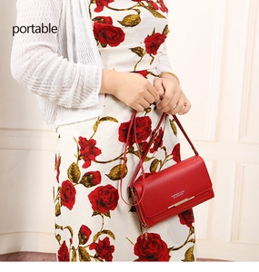 Close-up of red textured leather bag with gold metal trim and 'FASHION' lettering