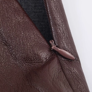 Dettaglio macro della gonna midi in pelle marrone scuro con cerniera invisibile