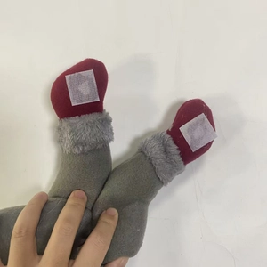 Detail of red and grey knitted plush doll legs with velcro strap for curtain tieback