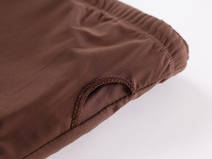Macro shot of dark brown knitted fabric with elastic hem and reinforced thumb hole detail