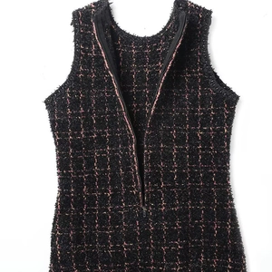 Dettaglio del tessuto in tweed nero e rosa con cerniera metallica sul retro del vestito