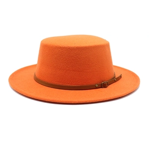 Détail d'un chapeau en laine orange à toit plat avec ceinture en cuir marron