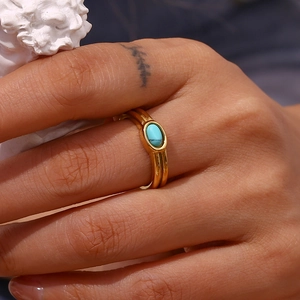 Gold-plated stainless steel double-band ring with oval turquoise stone on model