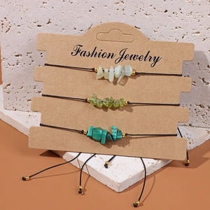 Detailed view of three green natural crystal stone bracelets on a display card