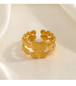 Detail of gold heart ring with 'for best' engraving on cream silk background