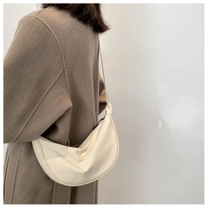 Close-up of minimalist off-white crescent hobo bag made of soft synthetic leather material