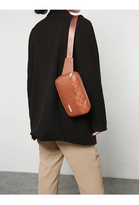 Brown quilted PU leather waist bag with gold zipper shown on a model in a black blazer