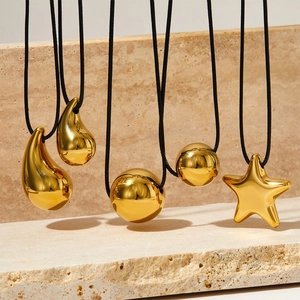 Polished gold stainless steel necklaces with heart, star and drop pendants on black cords