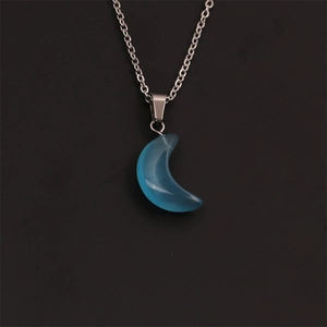 Vue détaillée du pendentif lune argenté avec pierre d'opale bleue sur fond noir élégant