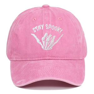 Detailed embroidery of Stay Spooky lettering and skull hand on pink washed cotton cap