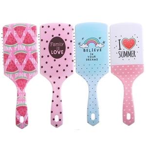 Close-up of four colorful air cushion hairbrushes with vibrant prints on a white background
