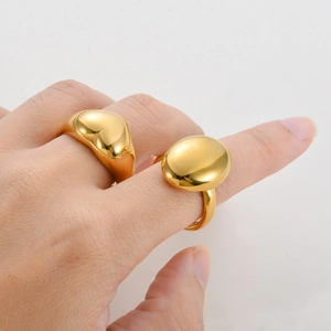 Polished gold stainless steel rings featuring 3D heart and oval shapes on a hand