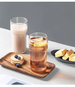 Stackable borosilicate glass cups with lemon tea and cake on a rustic wooden tray