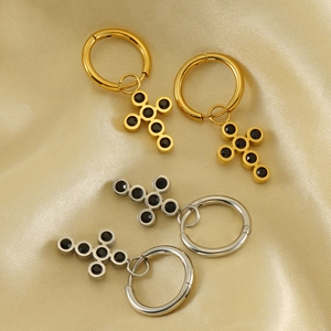 18k gold and silver stainless steel cross hoop earrings with black gemstones on silk background