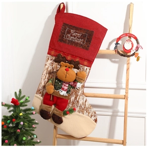Detail of 3D reindeer mascot and Merry Christmas patch on a hanging red holiday stocking