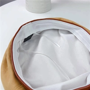 Close-up of the beret interior featuring suede fabric, leather trim, and adjustable drawstrings