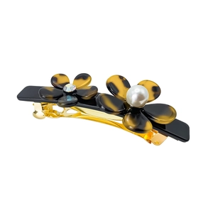 Detailed shot of acetate flower hair clip with pearl, rhinestone and golden base