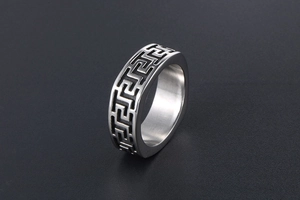 Macro shot of silver titanium steel ring featuring black etched Great Wall Greek pattern