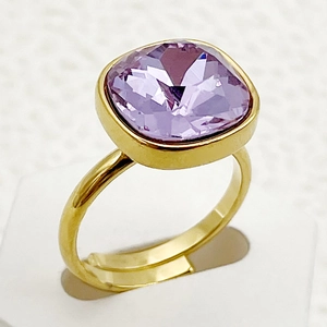 Gros plan d'une bague dorée réglable ornée d'un zircon violet de taille carrée