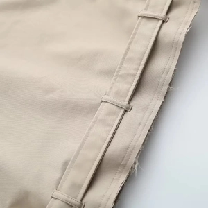 Gros plan sur le passant de ceinture et les coutures d'un trench-coat beige