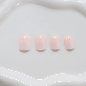 Pink gradient press-on nails with white polka dots and floral patterns for a fresh look