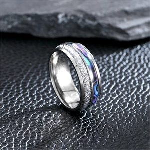 Detailed close-up of titanium steel ring with meteorite pattern and abalone shell inlay