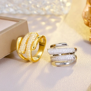 Detail of elegant gold and silver layered rings with pavé set zircon crystals