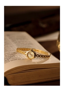 Detailed macro shot of a vintage gold quartz watch featuring a crystal-accented round dial