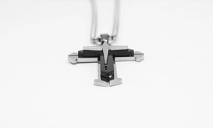 Detail of a multilayered silver and black cross pendant on a durable metal chain necklace