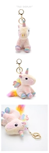 Detail view of pink unicorn plush keychain with rainbow wings and golden hardware
