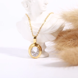 Detail of an 18k gold plated oval gemstone pendant necklace displayed on a white bust
