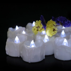 Detail of white LED tea light candles with realistic melting wax effect on black background