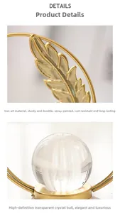 Detail of rust-proof gold iron leaves and clear crystal ball on a modern luxury stand