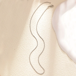Detailed view of a silver snake chain necklace with a lobster clasp closure