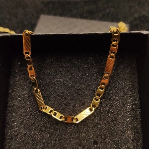 Close-up of golden stainless steel cable chain necklace inside a black jewelry box