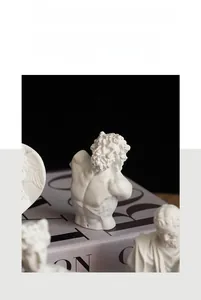 Miniature white resin bust sculptures arranged on a fashion book prop for home decor